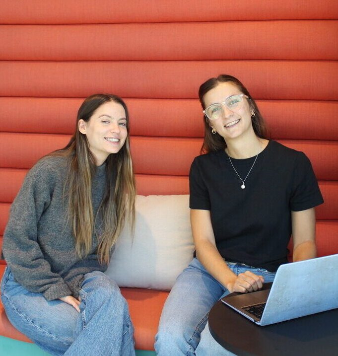Two members of the VEB Relocation team smiling with a laptop